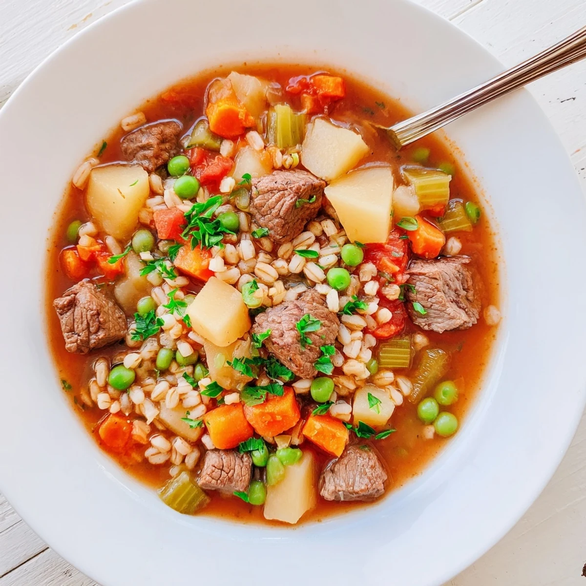 A close-up of Hearty Beef and Barley Vegetable Stew in a rustic bowl, garnished with fresh parsley.