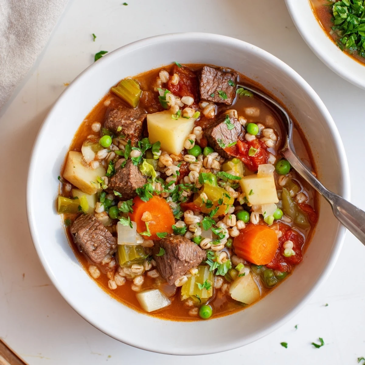 Hearty Beef and Barley Vegetable Stew steams in a Dutch oven next to crusty bread slices.