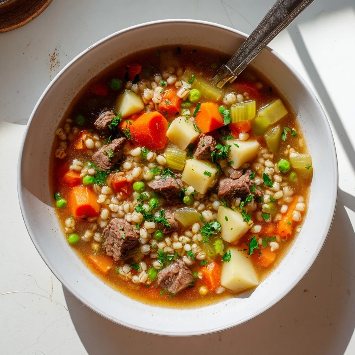 A ladle scoops Hearty Beef and Barley Vegetable Stew, revealing tender beef and colorful vegetables.