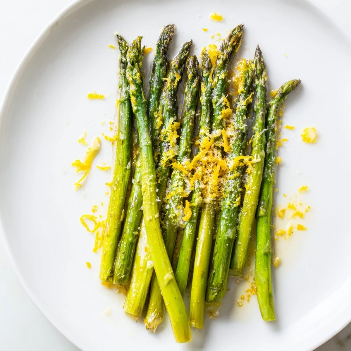 Roasted asparagus with Parmesan and lemon arranged on a baking sheet, showcasing tender green spears ready for oven roasting.