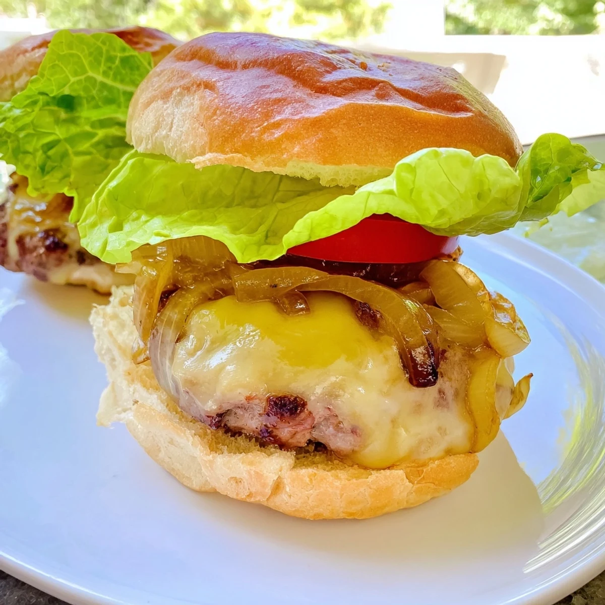 A juicy Beef Burger with Caramelized Onions and Swiss held by hands, showing the melted cheese and toasted bun texture.