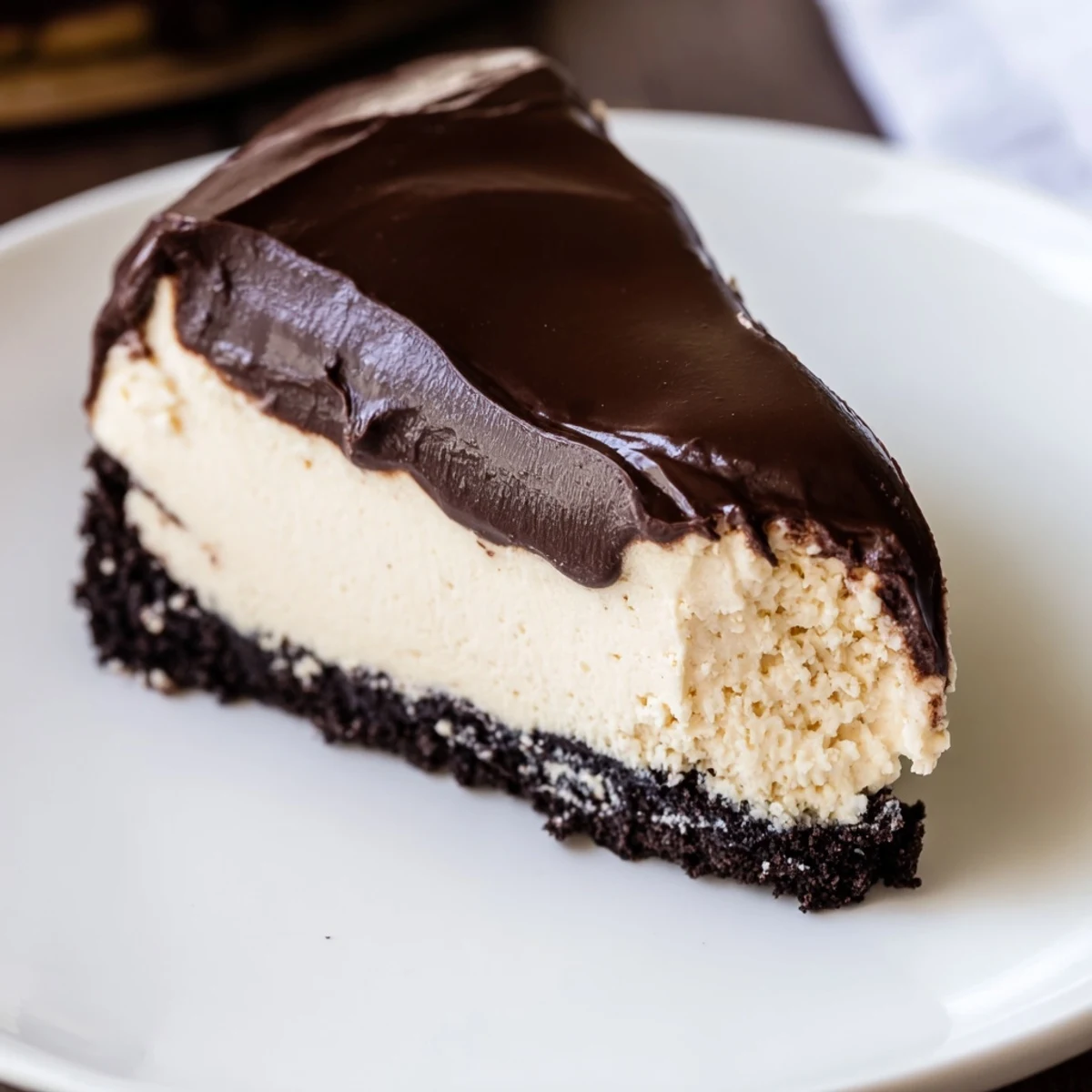 A creamy slice of Irish Cream Cheesecake with Chocolate Ganache ready to serve with coffee.