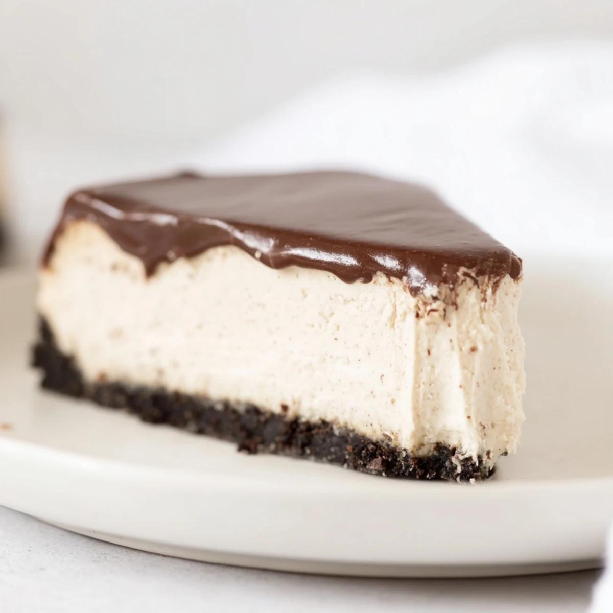 An Irish Cream Cheesecake with Chocolate Ganache, garnished with chocolate shavings, ready to serve at a dinner party.
