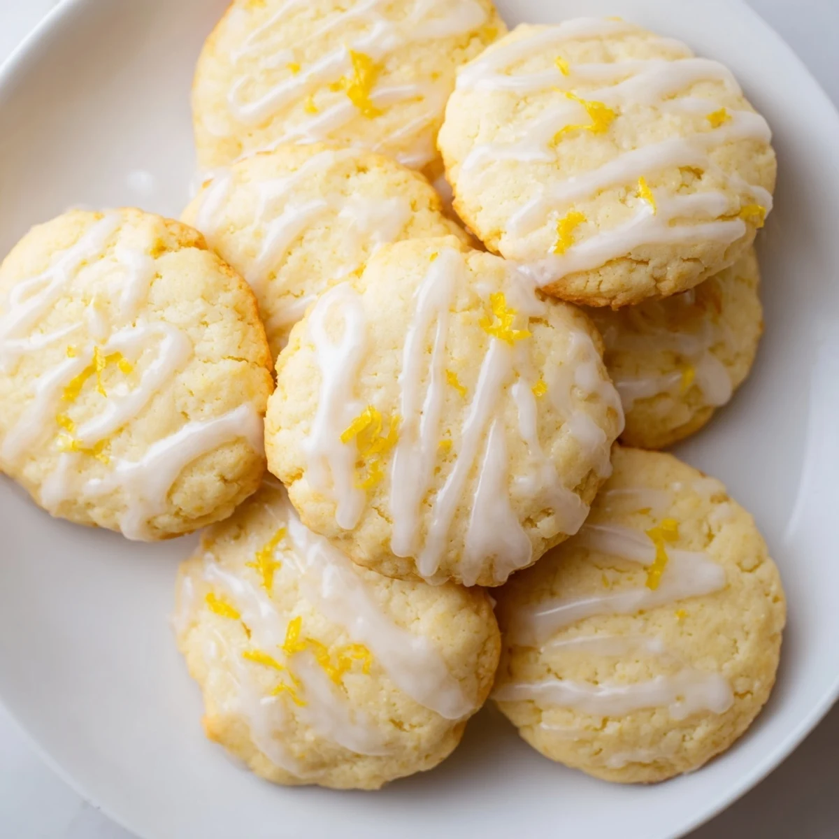 A close-up shows Lemon Ricotta Cookies with Lemon Glaze, the golden edges and moist crumb glistening under a bright citrus glaze.