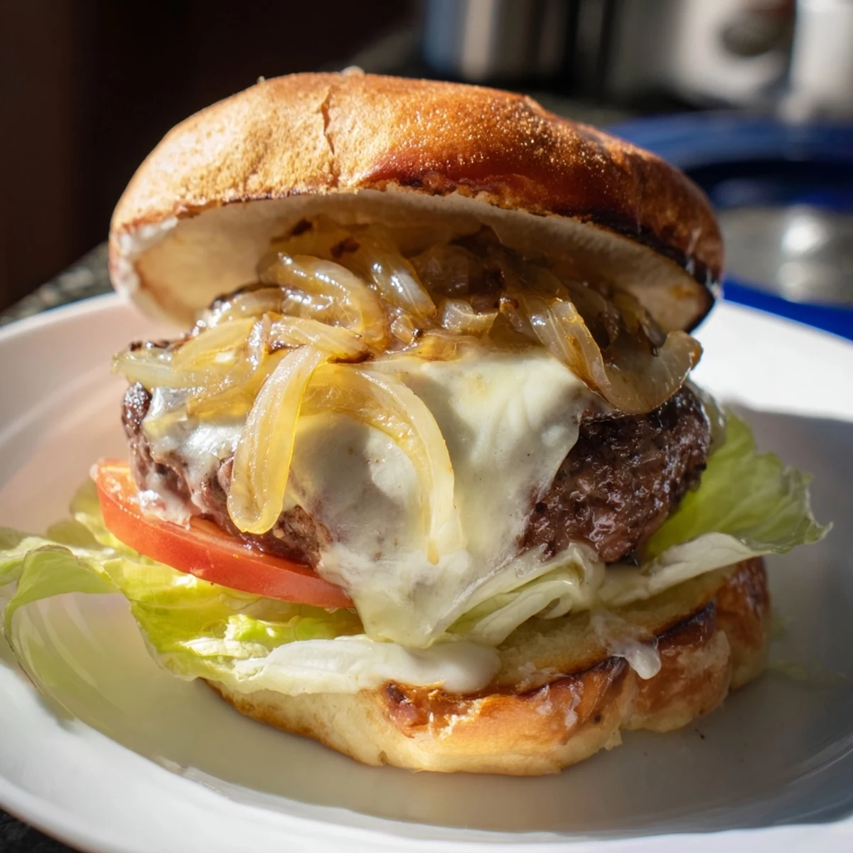 Close-up of a Beef Burger with Caramelized Onions and Swiss, highlighting melted cheese and golden onions on a sesame bun.