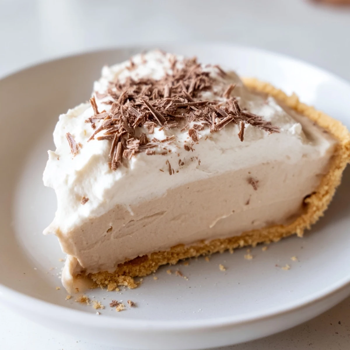 A whole Irish Cream Cheesecake rests on a cooling rack, showing off its smooth surface and golden biscuit base.