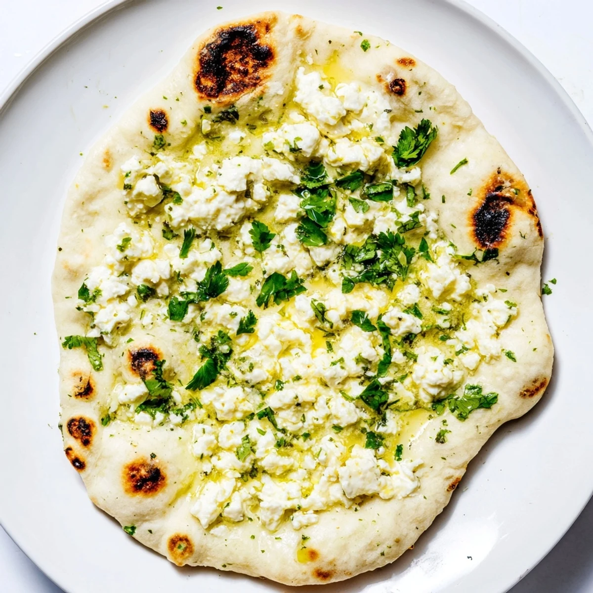 Freshly baked Cottage Cheese Garlic Naan showing bubbly edges and melted cottage cheese filling on a rustic wooden table.