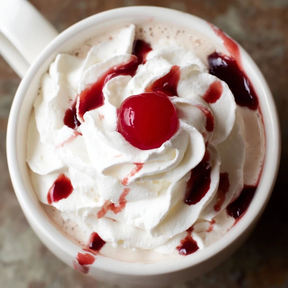 The Viral Cherry Vanilla Latte features a glossy cherry drizzle cascading down the sides of a mug.