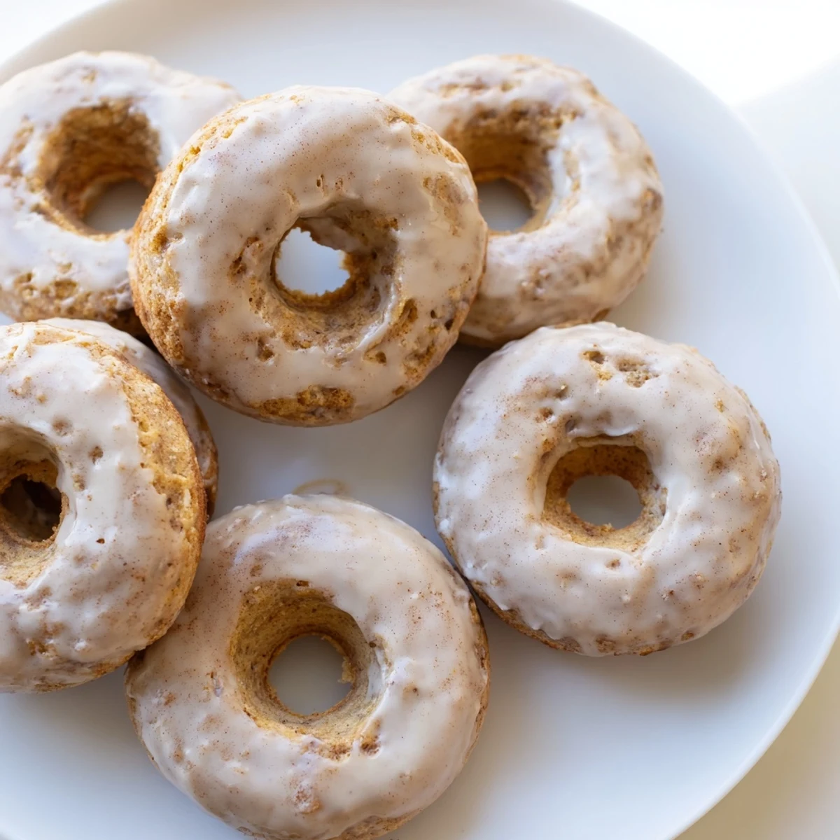 Freshly baked Baked Banana Bread Donuts on a wire cooling rack, showing moist crumb and golden edges.