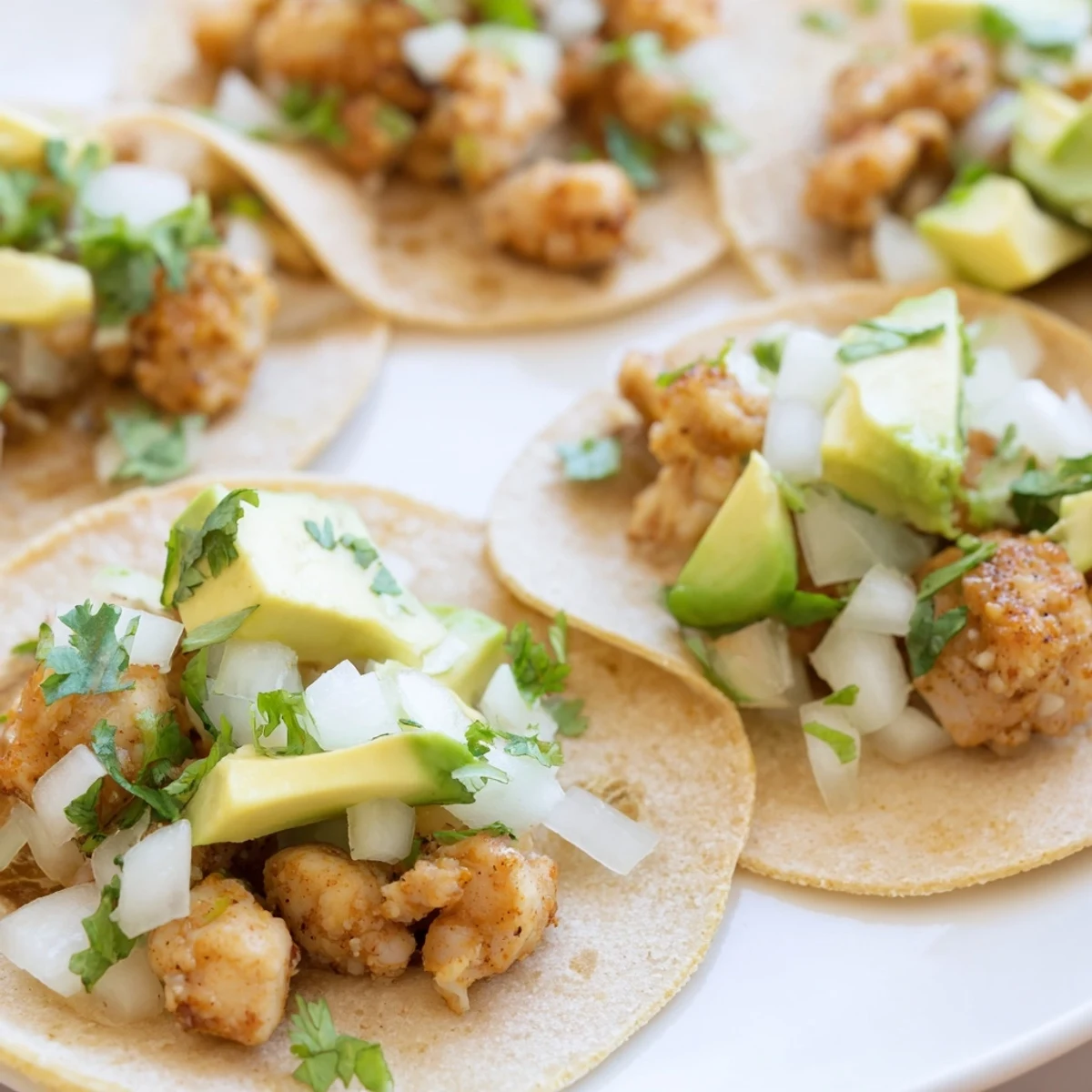 Freshly assembled chicken street tacos with crumbled cotija cheese and vibrant salsa on the side.