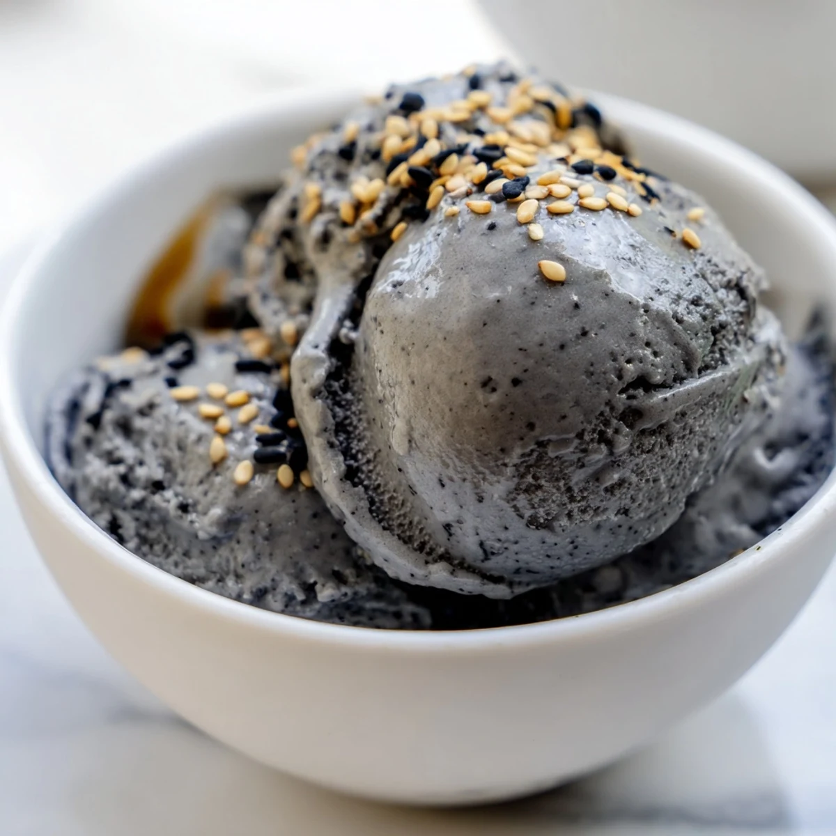 Close-up view of creamy Toasted Black Sesame Ice Cream with a dark nutty swirl, perfect for dessert lovers.  
