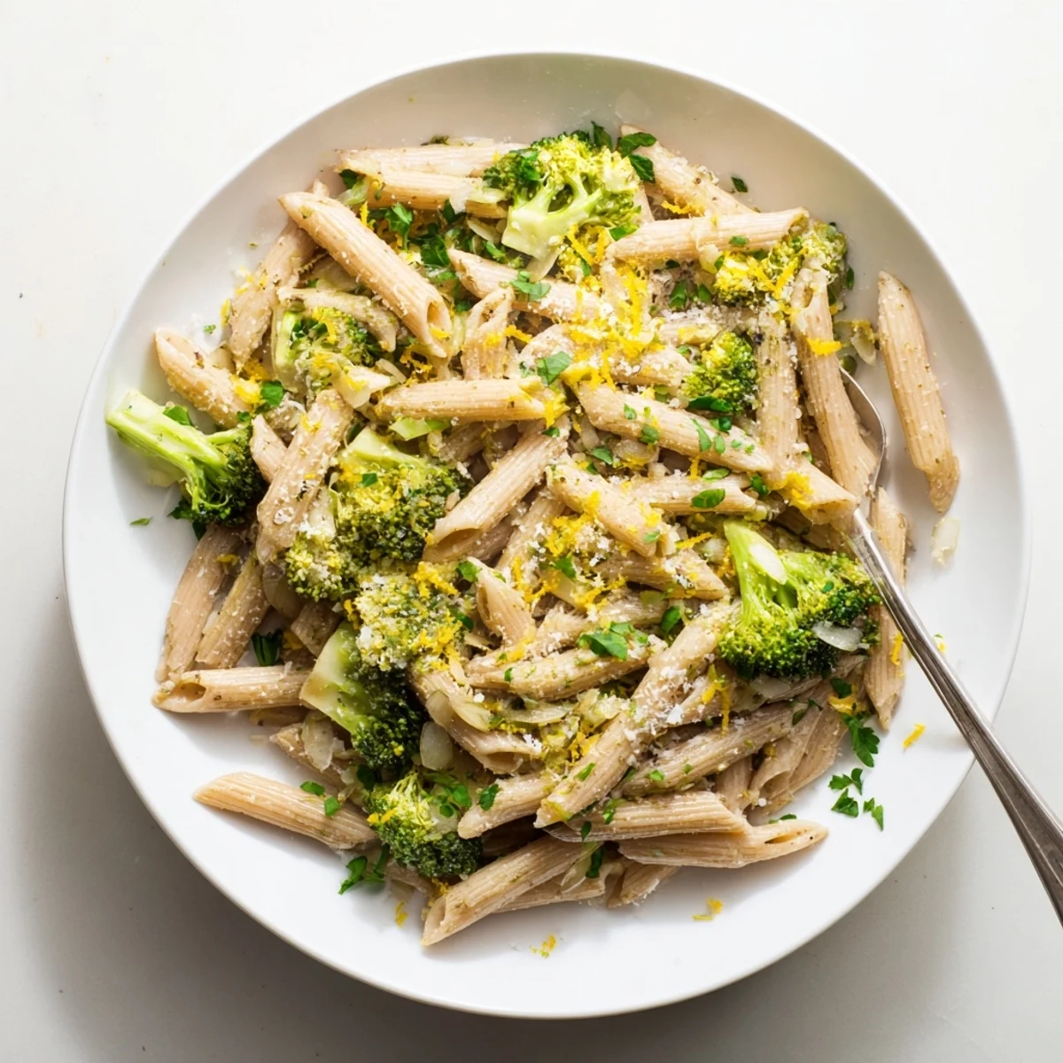 Freshly cooked whole wheat penne and vibrant green broccoli florets tossed in a garlic olive oil sauce, with a sprinkle of Parmesan and lemon zest.