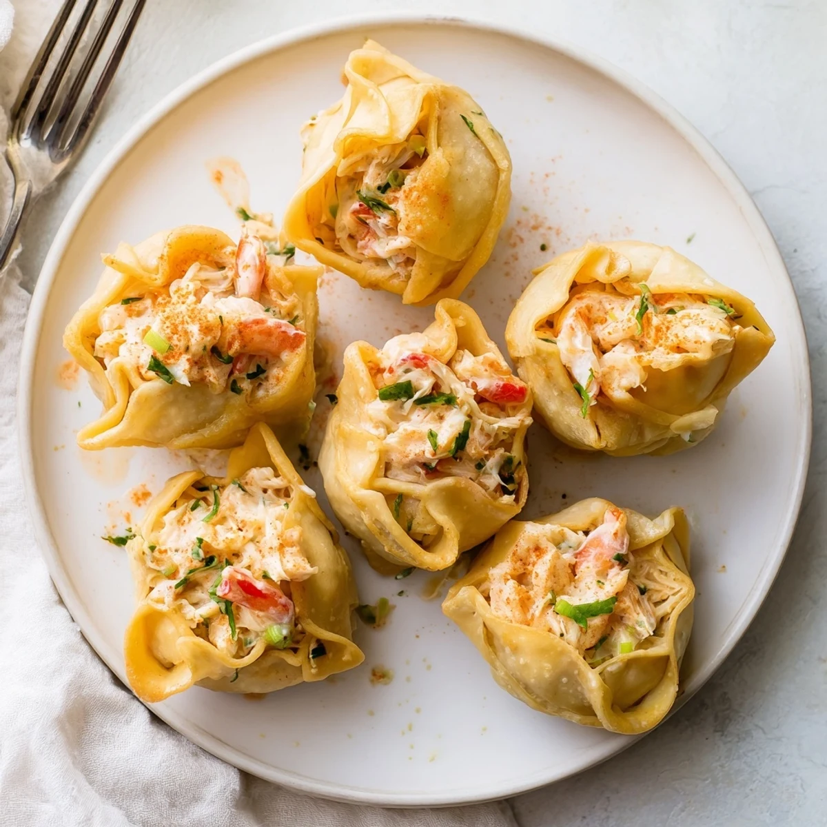 Cheesy Seafood Tortilla Bombs sit on a white plate with parsley garnish, golden crispy texture visible.