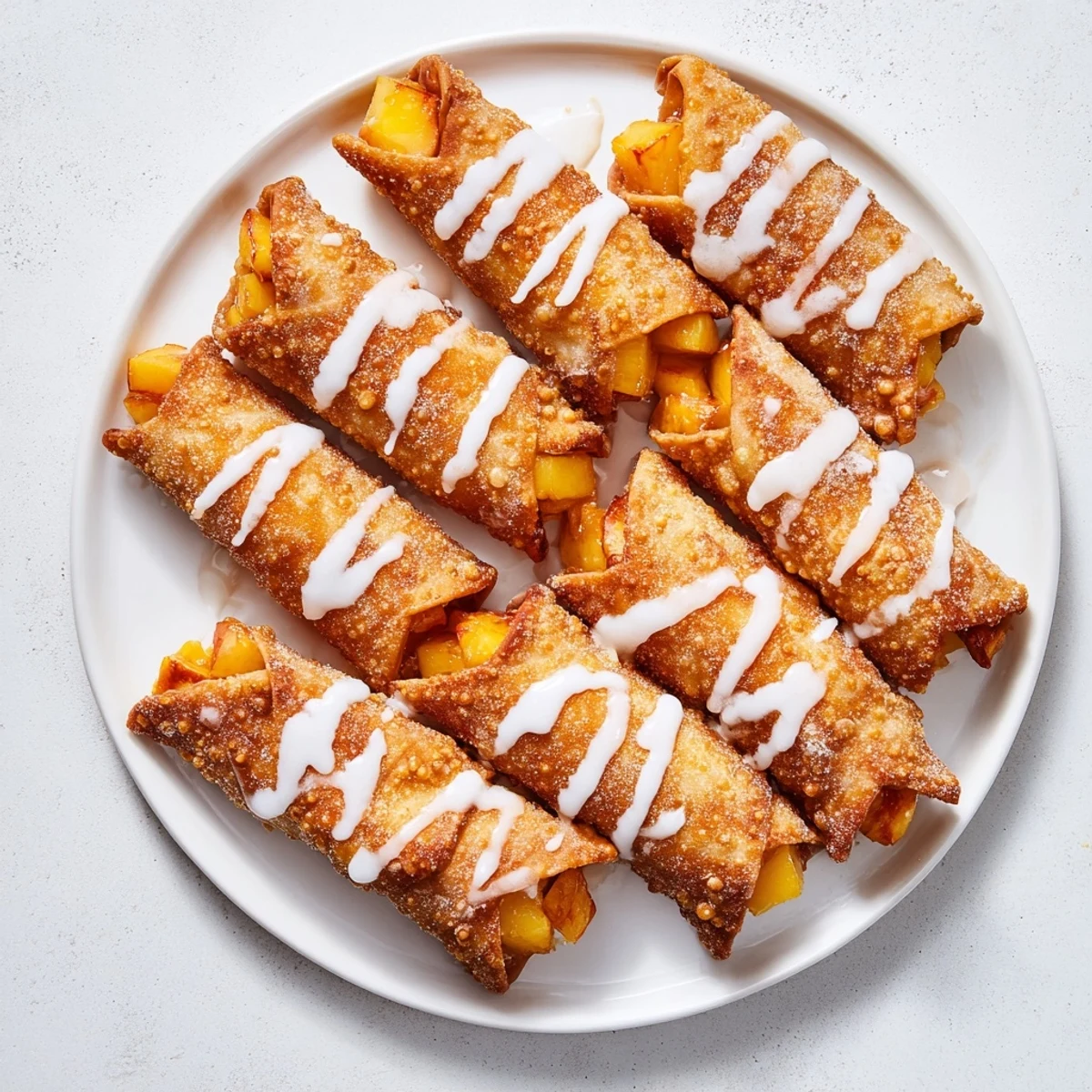 Handheld dessert featuring warm peach filling wrapped in crunchy golden brown pastry shell