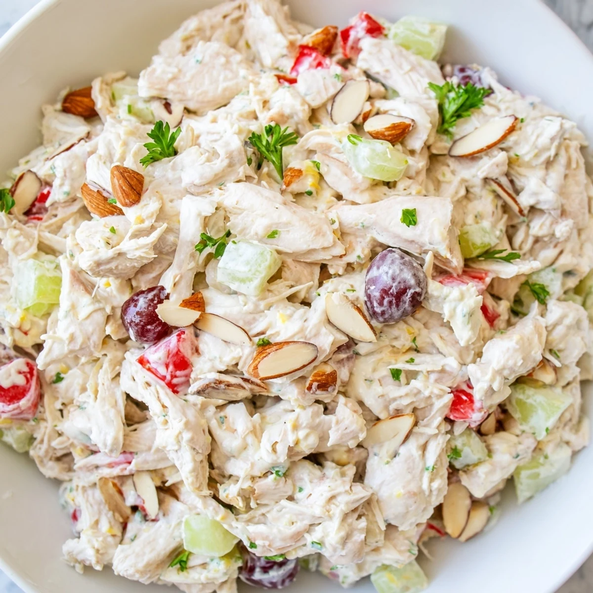 Light protein-packed Greek yogurt chicken salad served on fresh greens with almonds and cranberries