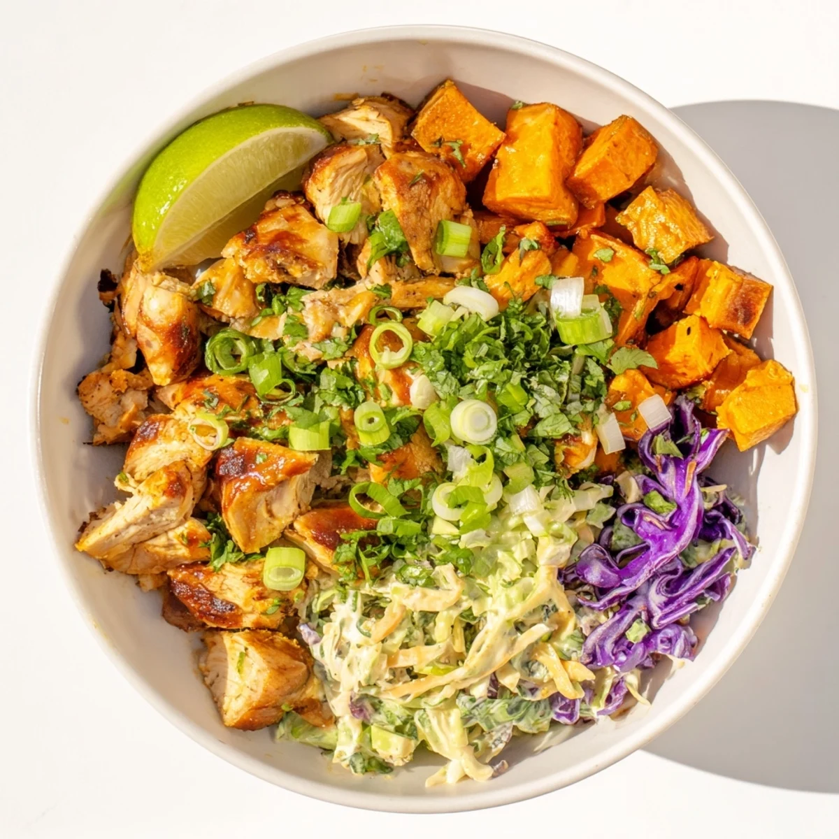 Sliced grilled BBQ chicken over crispy roasted sweet potato cubes with tangy coleslaw