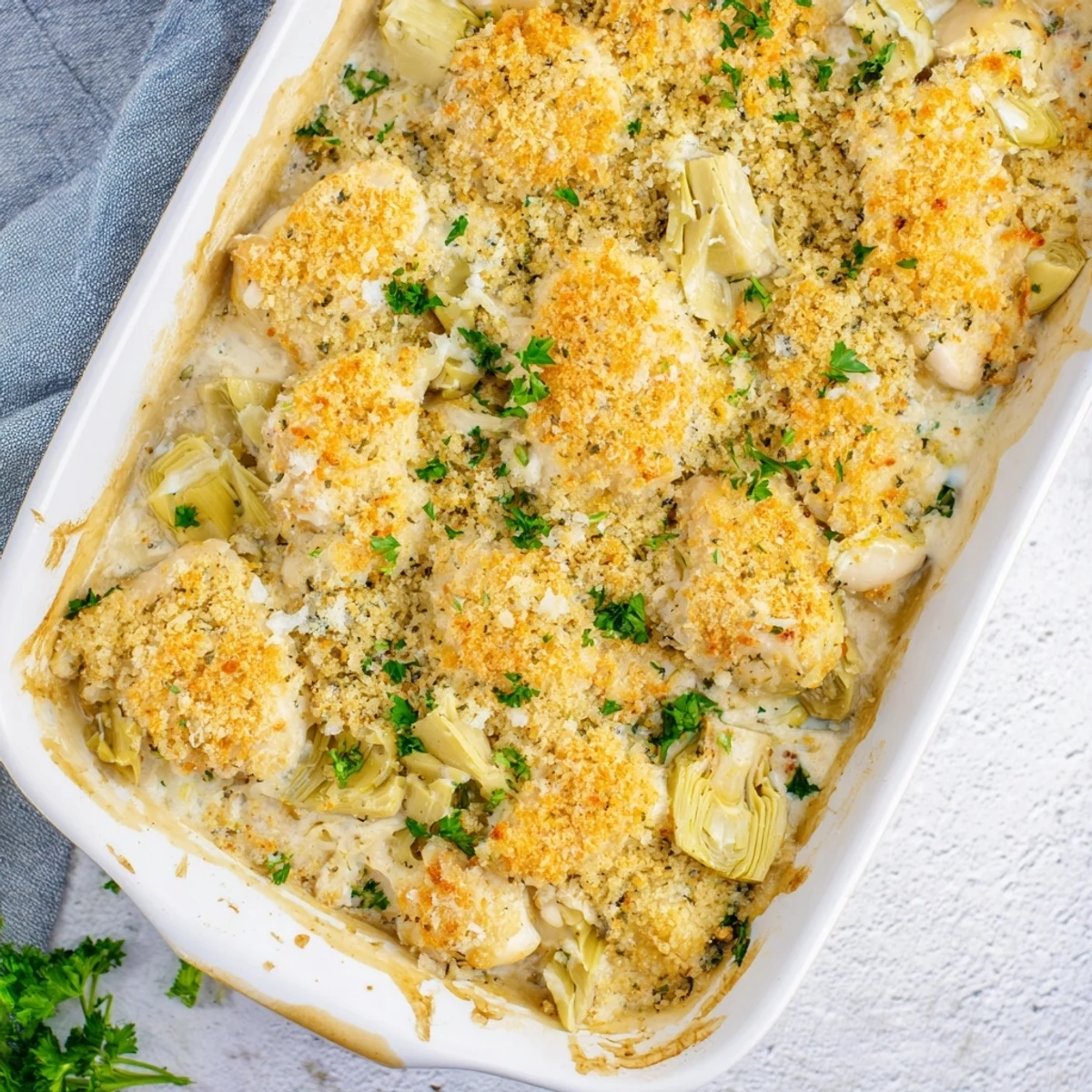 Creamy artichoke chicken bake casserole with tender chicken and melted mozzarella cheese topping