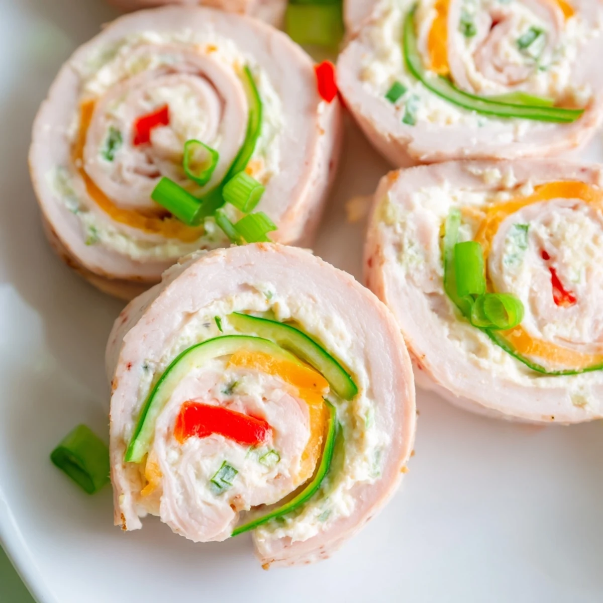 Creamy keto ham roll ups filled with cheddar cheese and crisp colorful vegetables