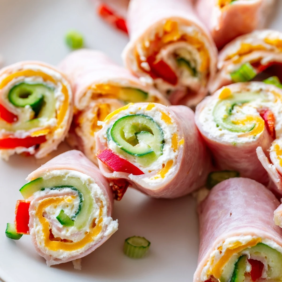 Bite-sized keto ham roll ups showcasing layered ham, cream cheese filling, and fresh cucumber