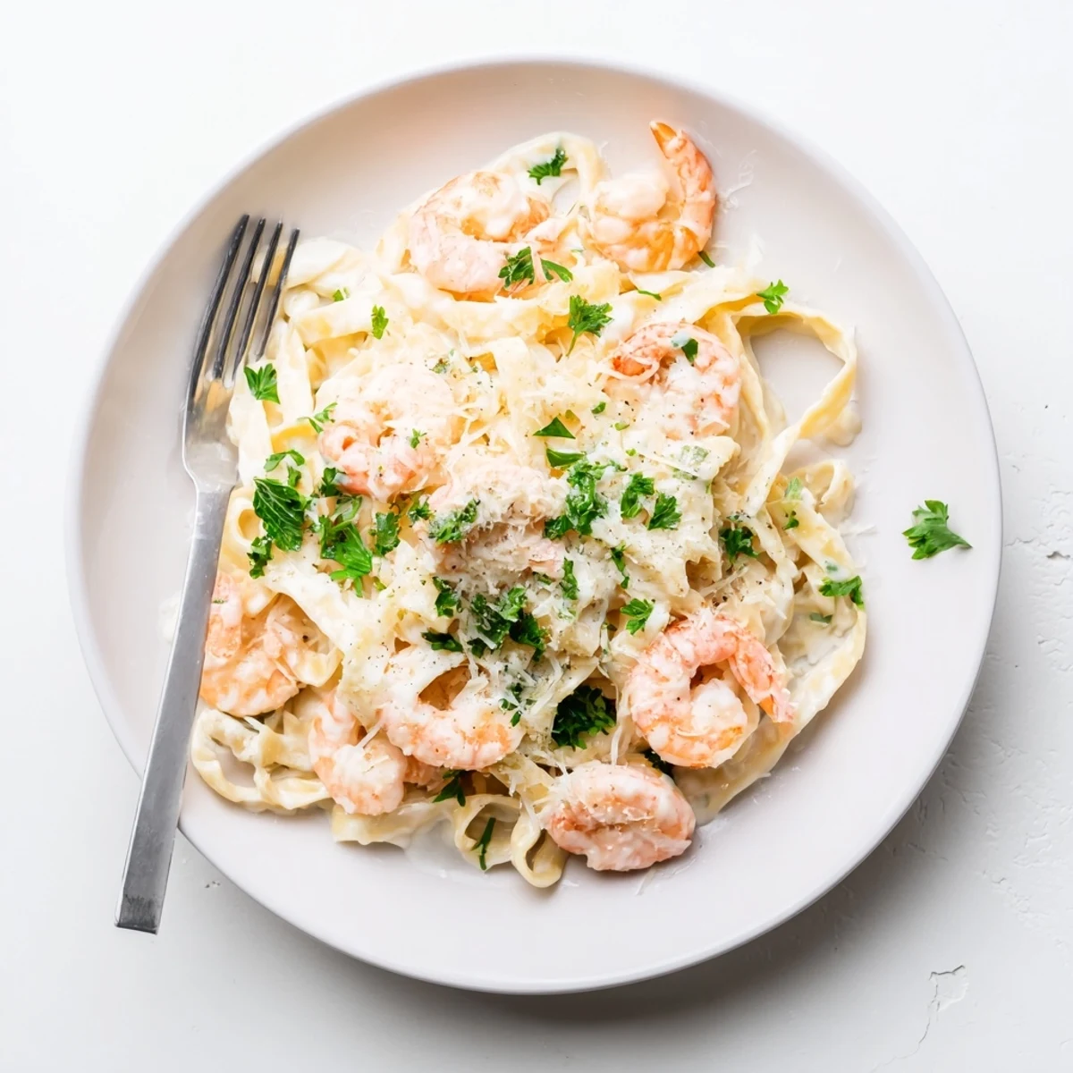 Homemade Alfredo sauce coats perfectly cooked fettuccine and pink shrimp in this comforting Italian-American pasta dish
