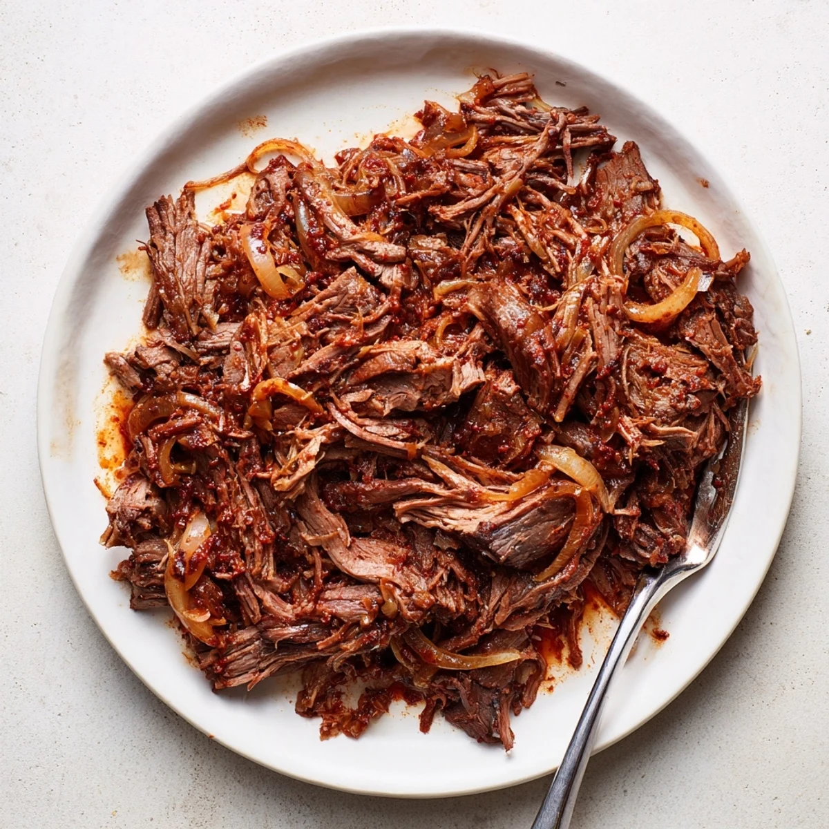 Fork-tender slow cooker shredded beef coated in aromatic spices and savory juices
