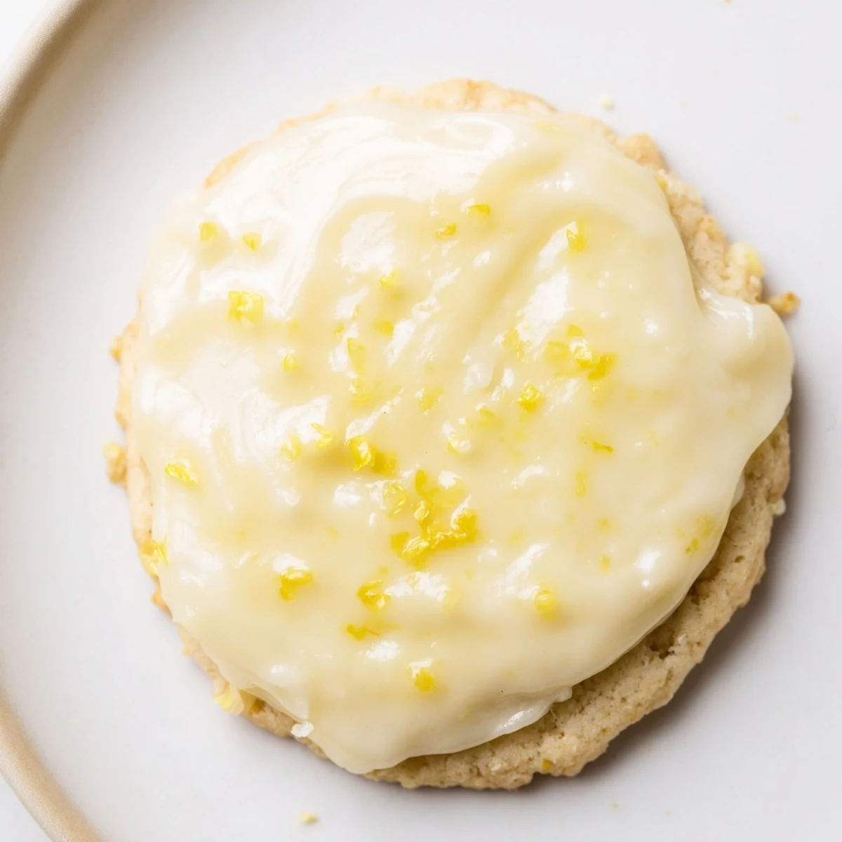 Homemade lemon frosted cookies with bright citrus glaze cooling on a parchment-lined baking sheet