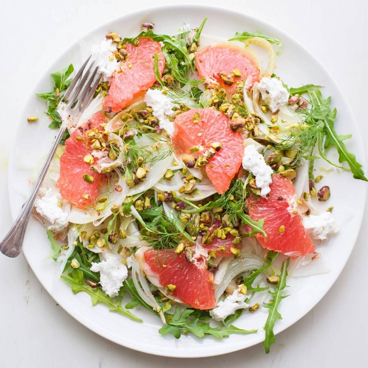 Grapefruit goat cheese and fennel salad featuring juicy pink citrus slices, shaved fennel, toasted pistachios, and tangy goat cheese