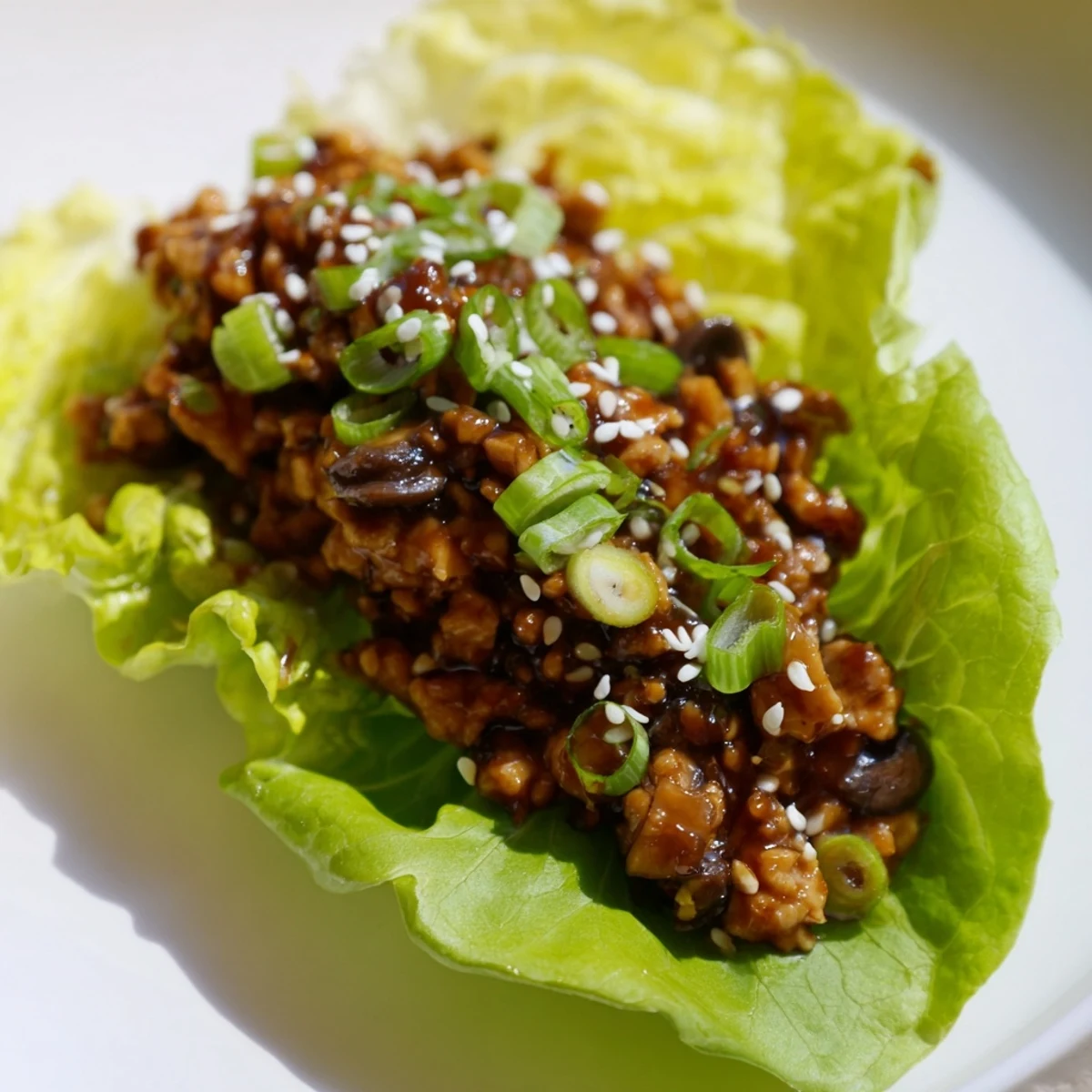 Golden brown chicken lettuce wraps with hoisin glazed filling in crisp butter cups