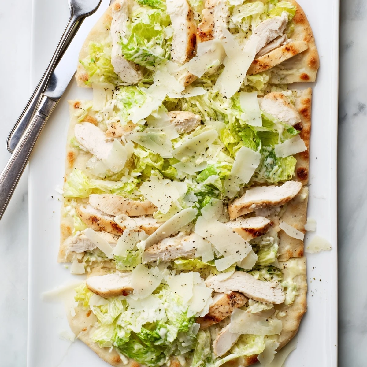 Homemade chicken Caesar flatbread with juicy seasoned chicken breast, melted cheese, and tangy Caesar toppings
