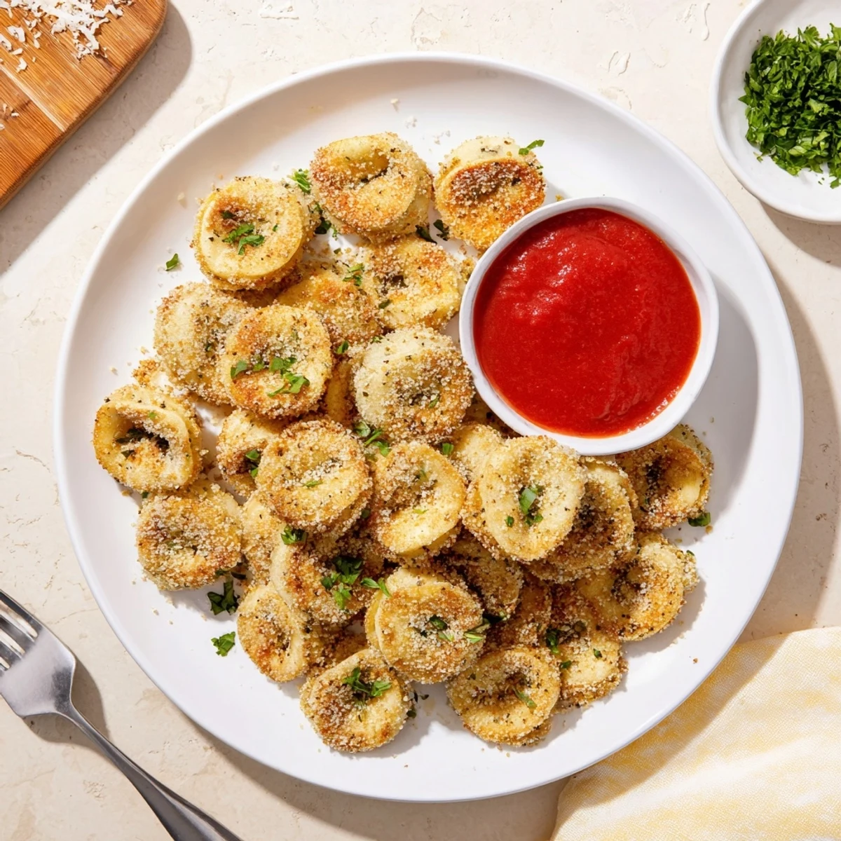Golden crispy air fryer tortellini arranged on a platter with warm marinara dipping sauce