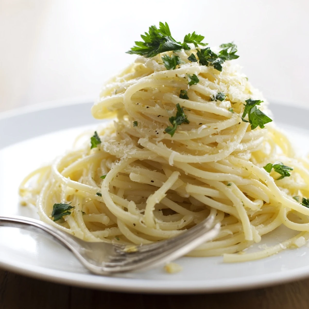 Steaming plate of one pot garlic butter pasta with lemon zest and parmesan cheese sprinkled on top