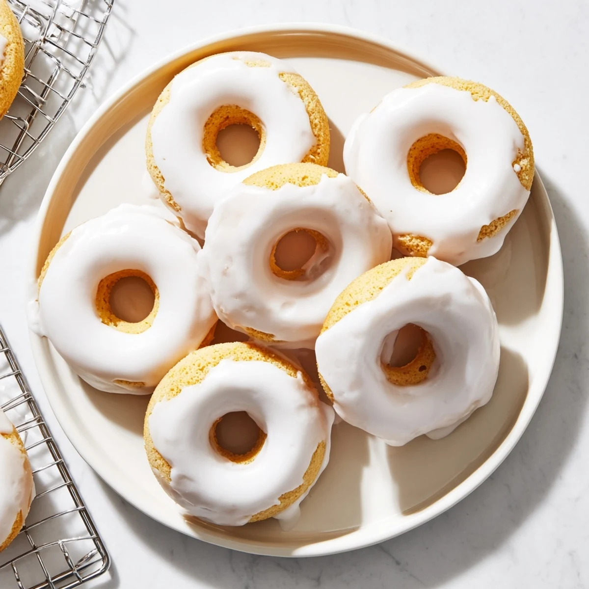 Light and fluffy Greek yogurt cake donuts arranged on a white serving plate, dusted with powdered sugar