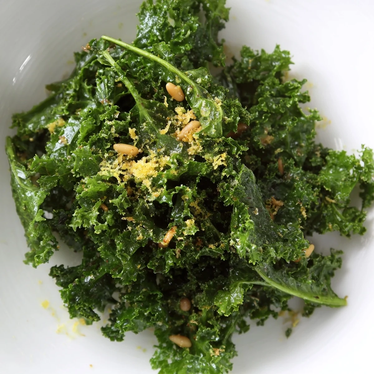 Bright green massaged kale leaves glistening with zesty Garlic Lemon Parmesan Kale Salad dressing