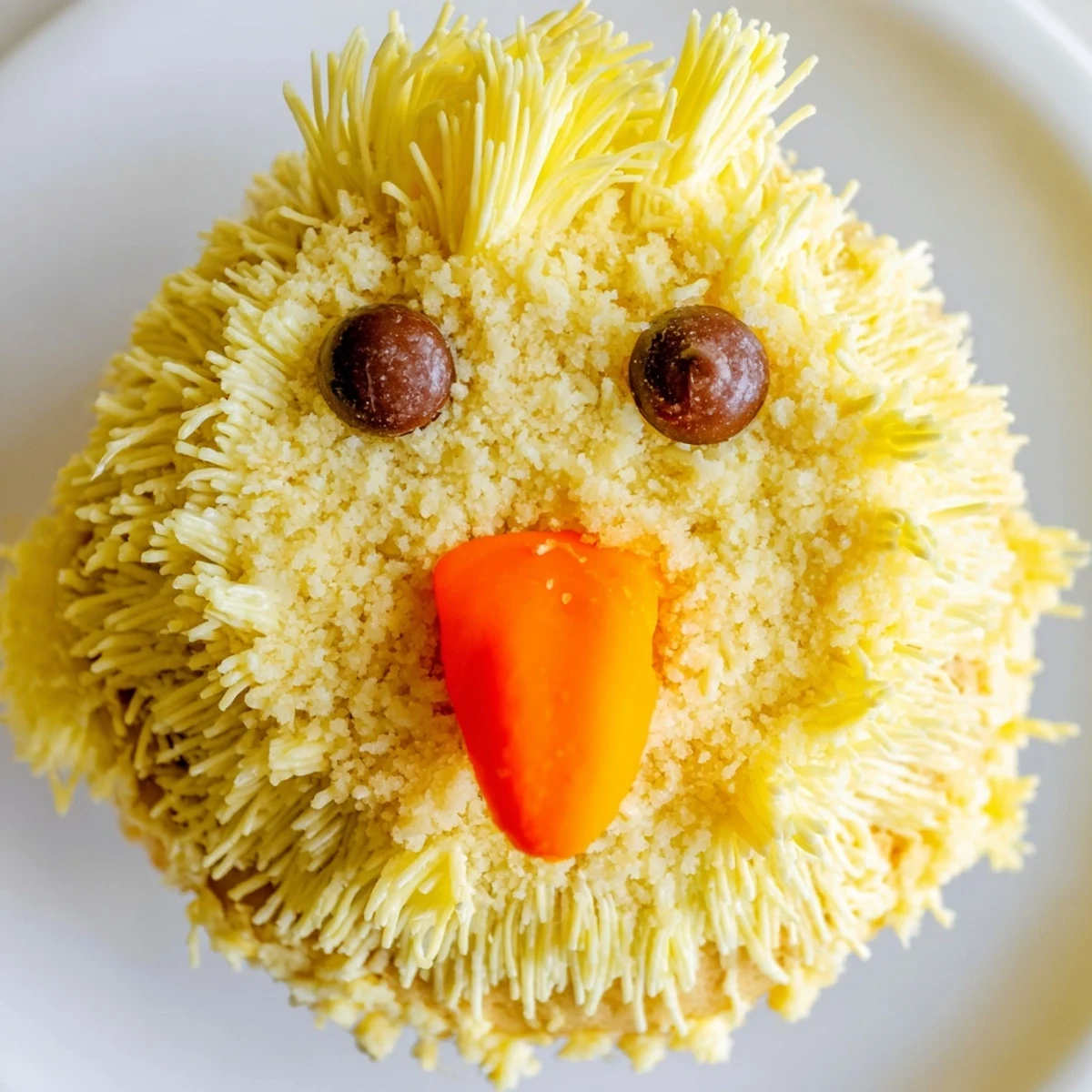 Adorable Easter chick cupcakes with fluffy yellow frosting and sweet candy faces on display