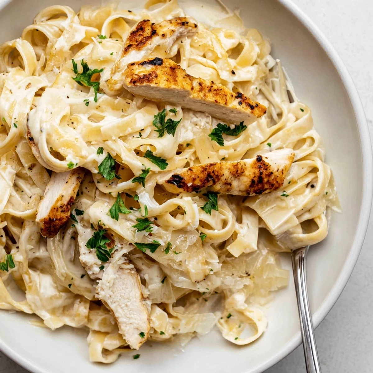 Skillet-style Creamy Garlic Chicken Pasta tossed with parsley, freshly grated Parmesan