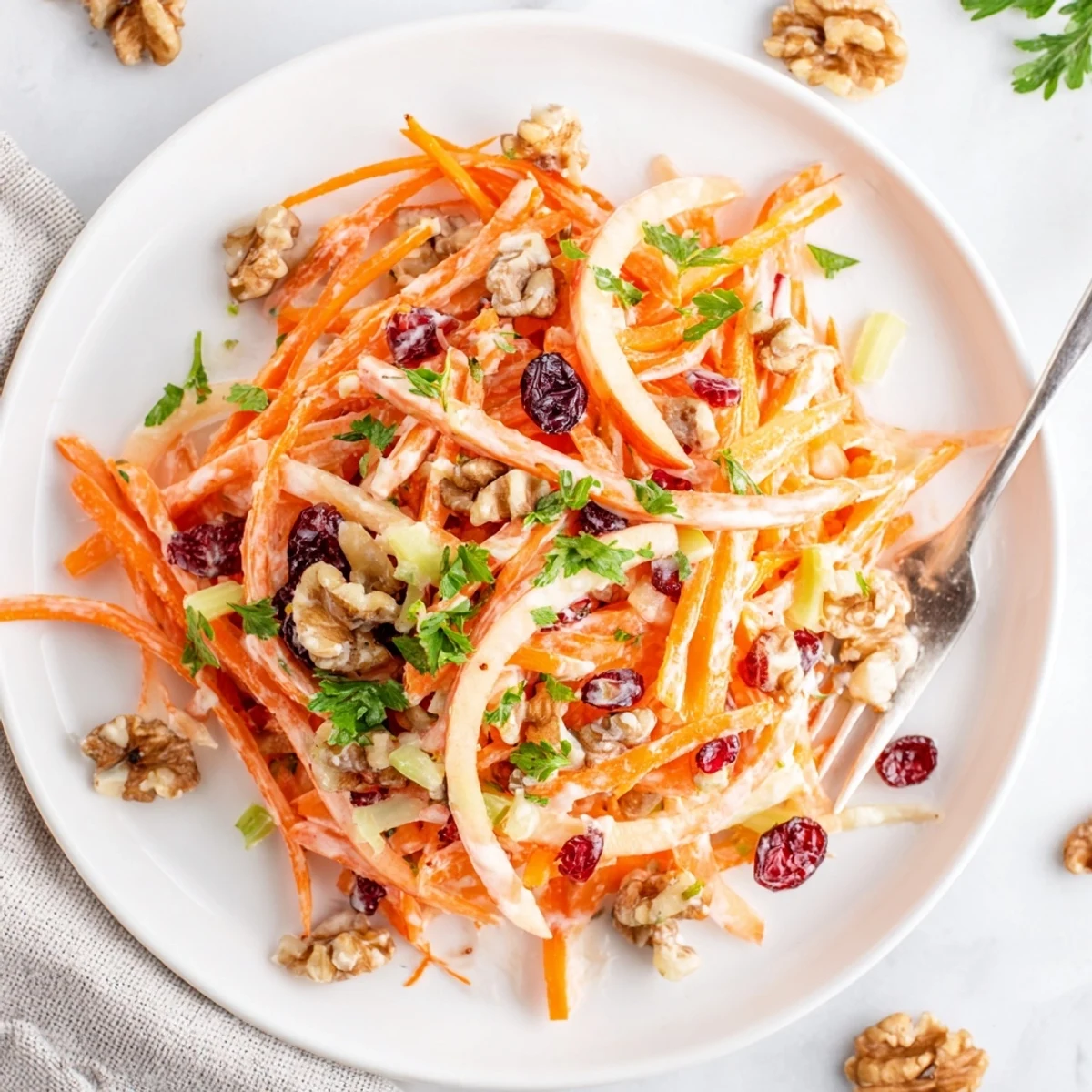 Served chilled, Crunchy Apple Carrot Salad With Creamy Citrus Dressing topped with fresh parsley