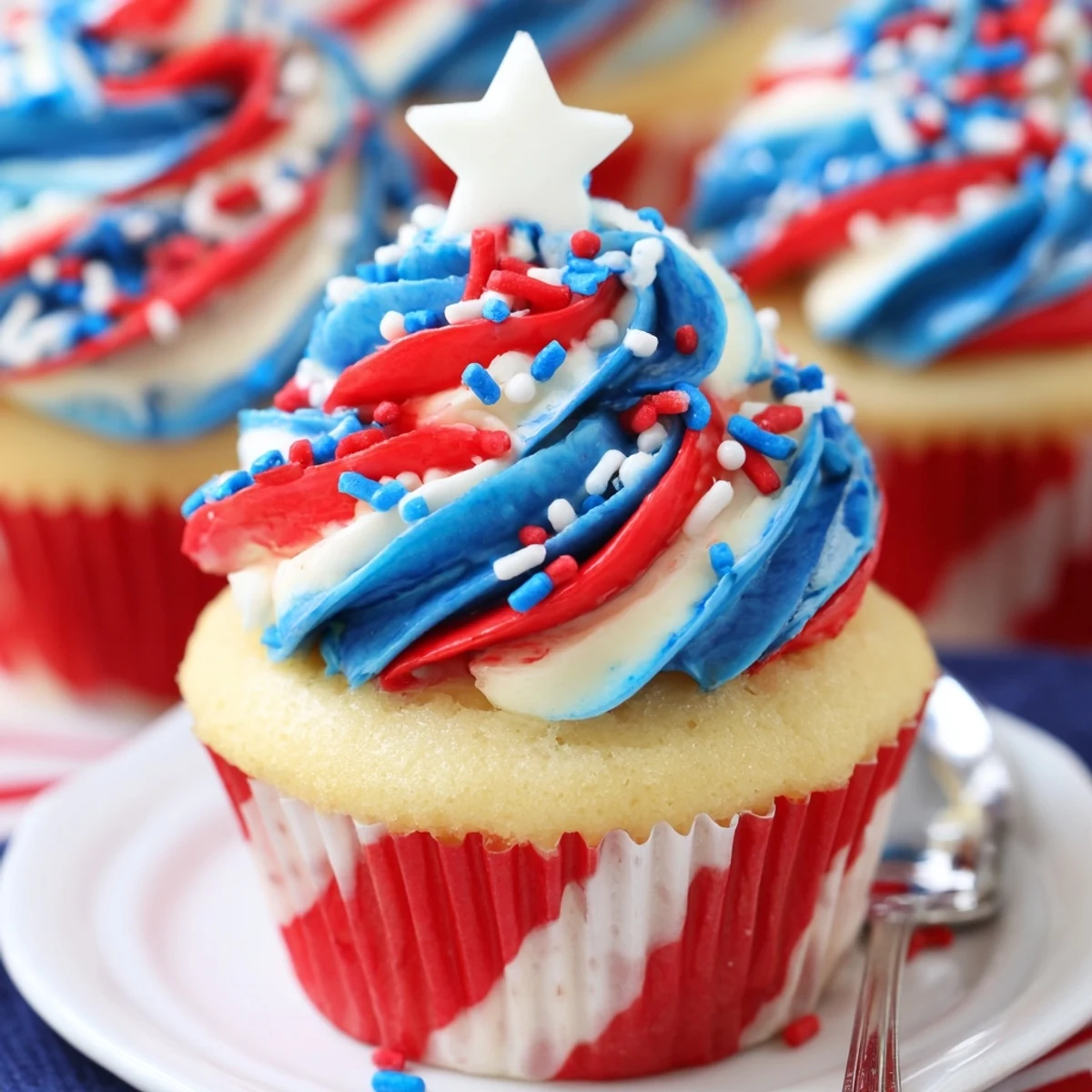 A plate of Patriotic Firework Cupcakes topped with crunchy sprinkles, ready for picnics