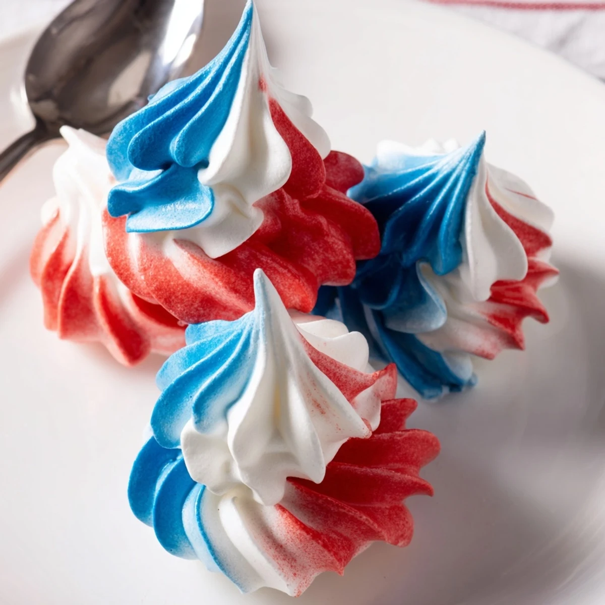 A pile of Patriotic Meringue Kisses glistening, airy, perfect for summer parties.