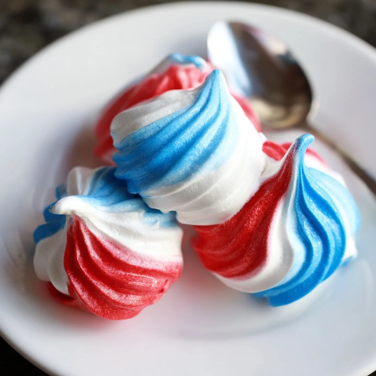 Oven cooled Patriotic Meringue Kisses showcased on tray, delicate crunchy shells, festive.