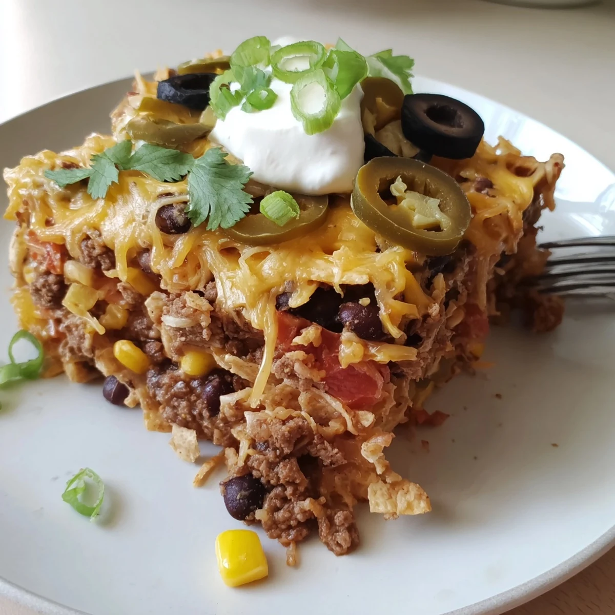 A skillet-baked Cheesy Nacho Casserole steaming, crunchy chips beneath gooey, stretchy cheese