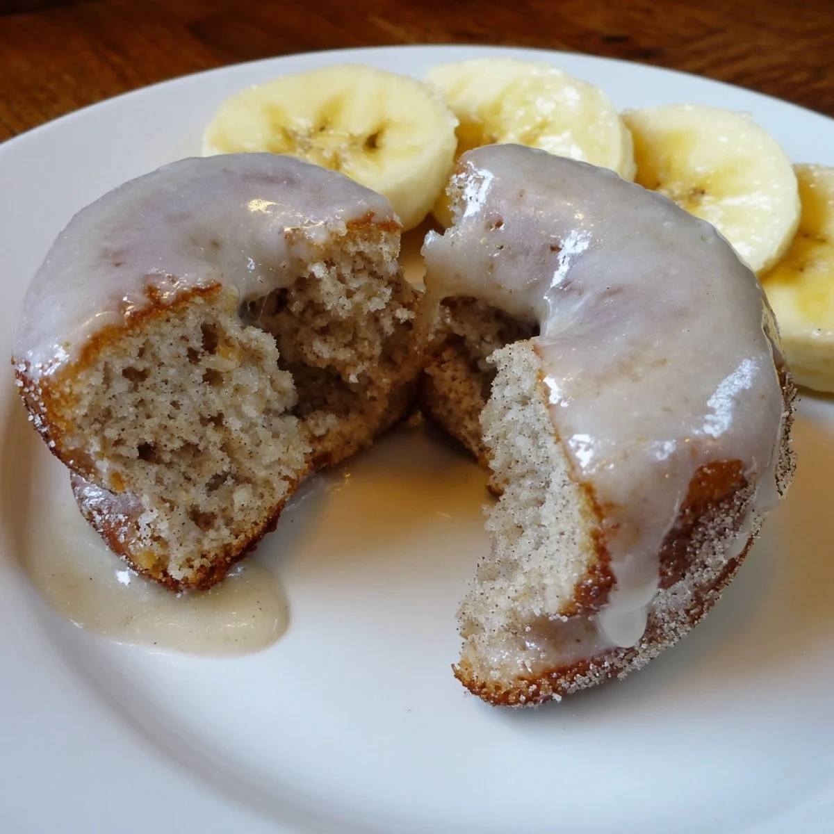 Close-up of sliced Banana Donuts revealing moist interior, cinnamon flecks, glaze.