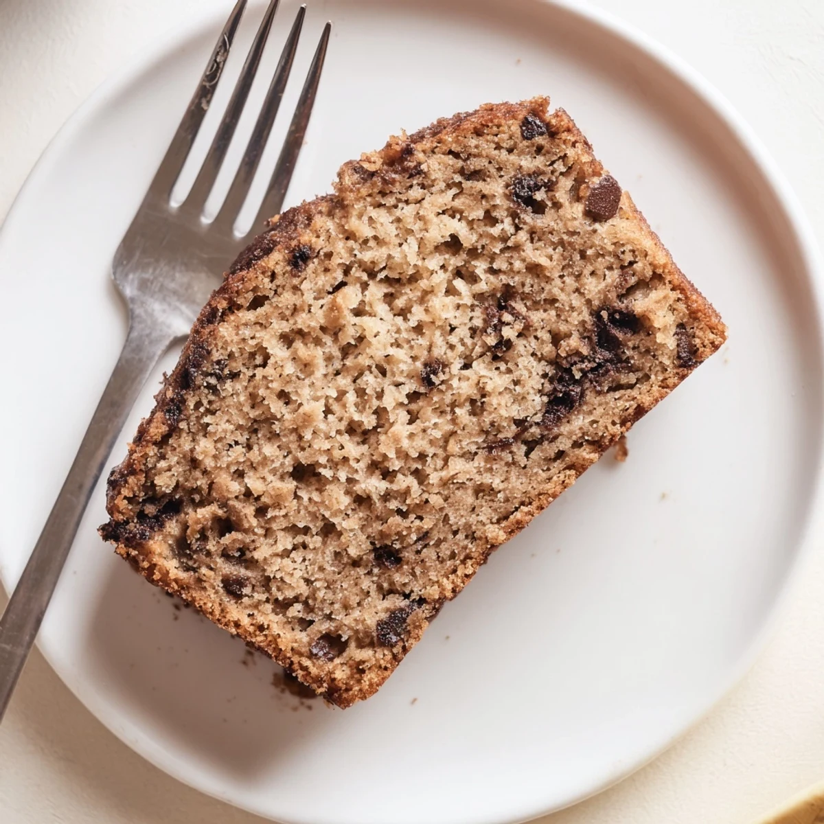 Moist oil-free protein banana bread with a perfectly crumbed texture on a white plate