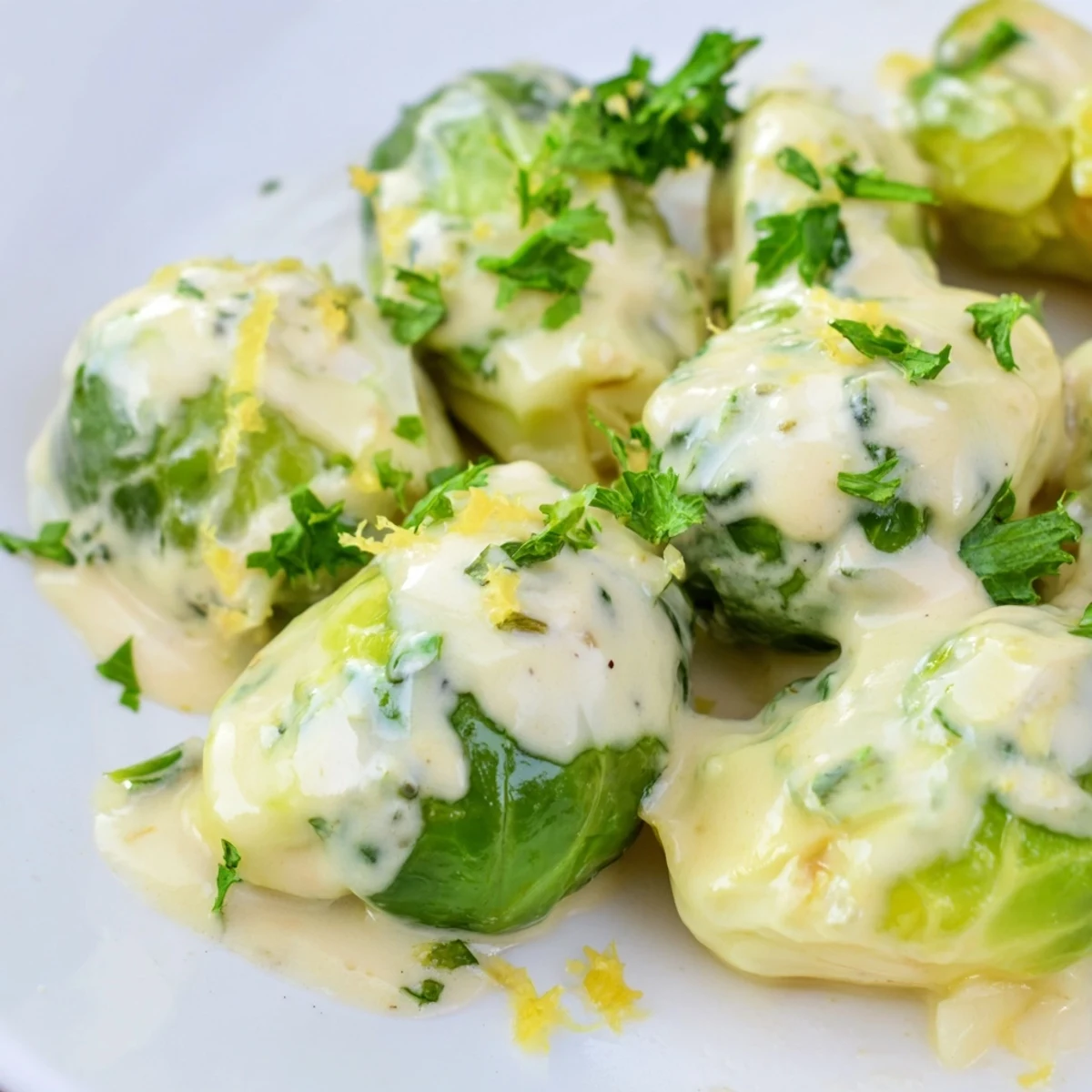 Creamy Boursin cheese sauce cloaks tender pan-seared Brussels sprouts on a white serving platter