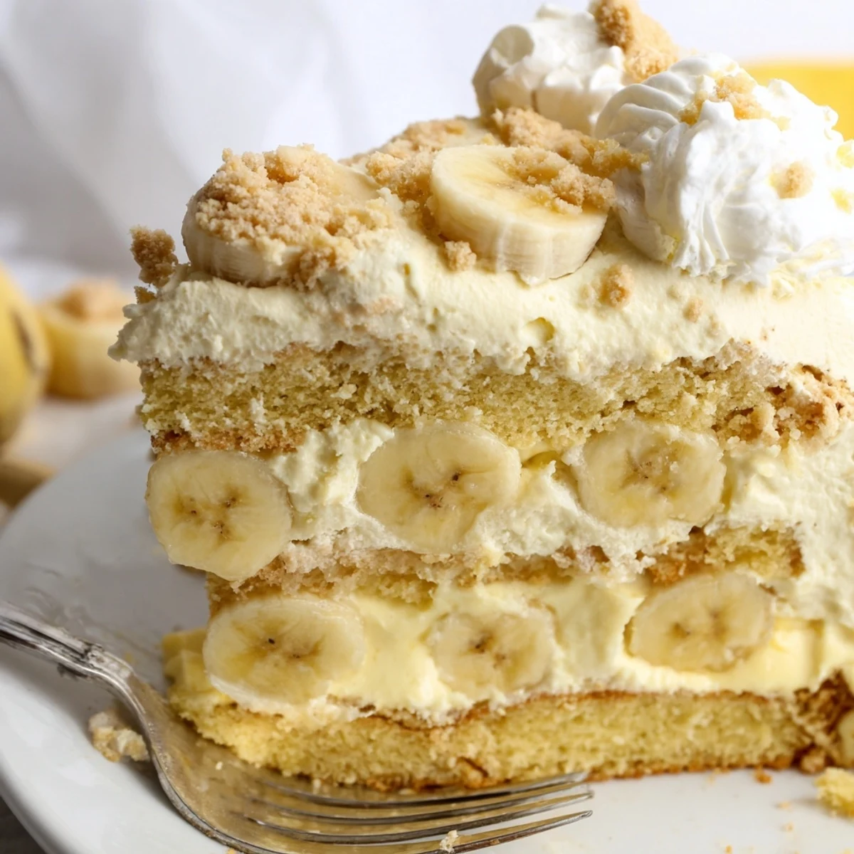 Golden banana pudding cake layered with creamy vanilla filling and fresh sliced bananas
