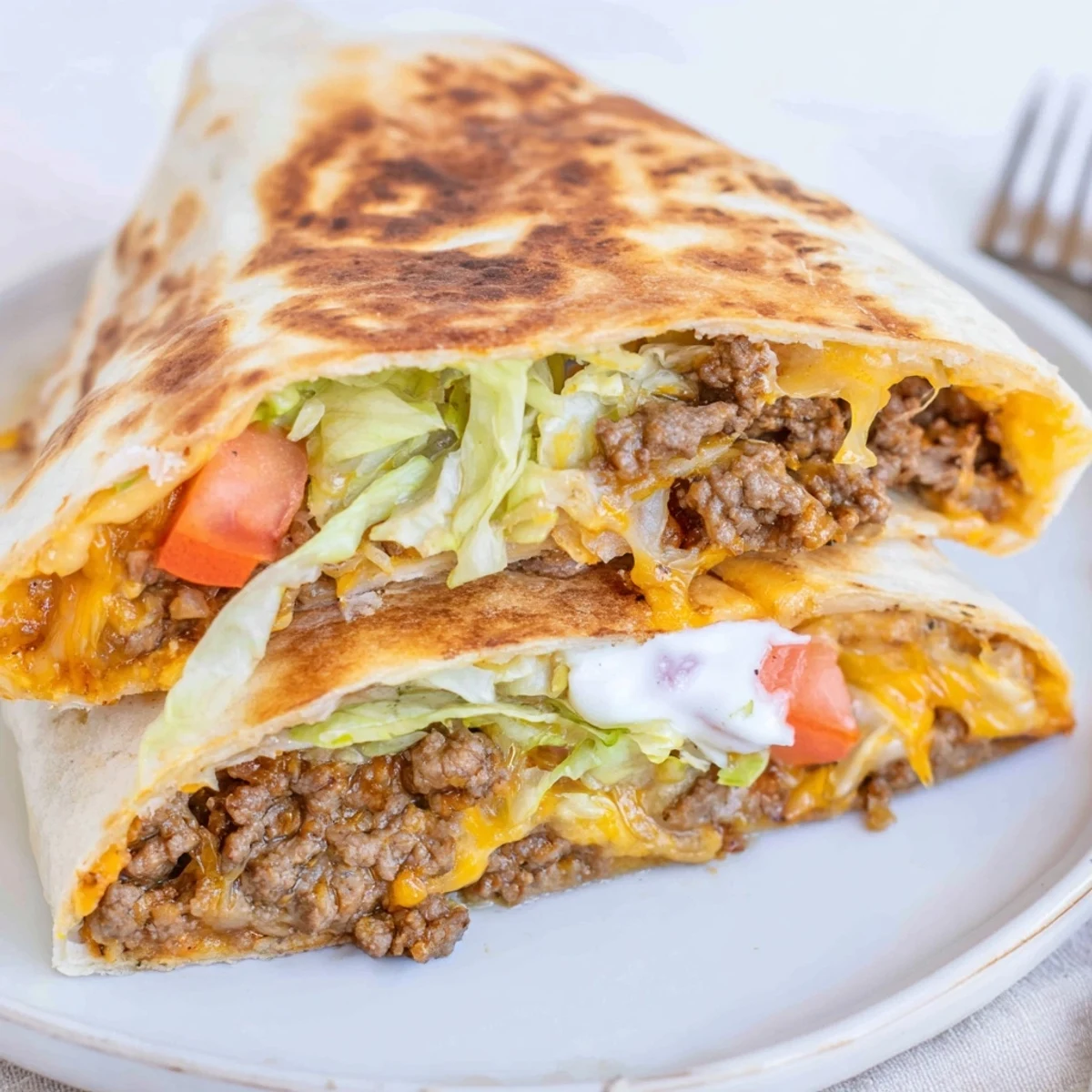 Warm Ultimate Cheesy Beef Crunch Wraps crisped golden, served with salsa and lime