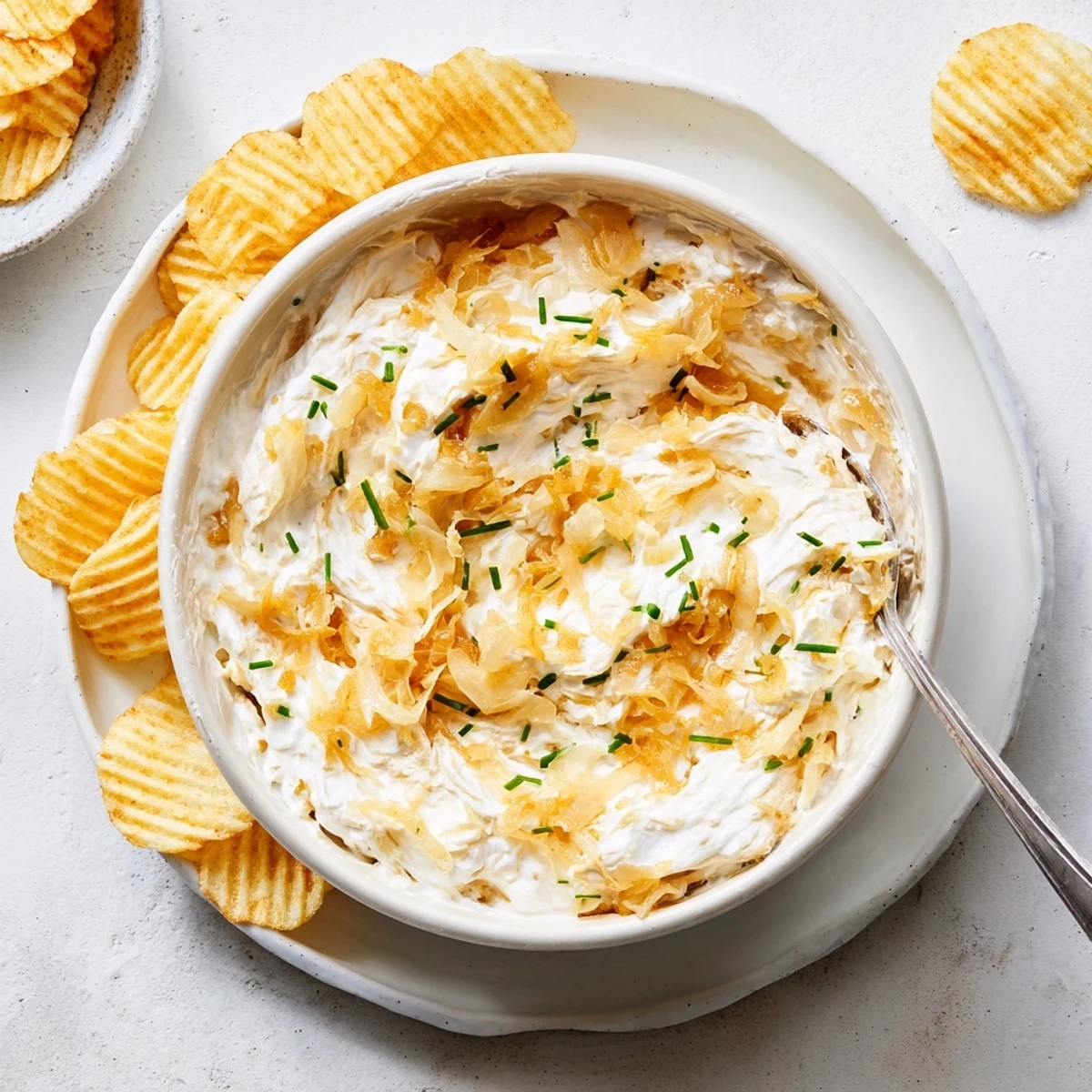 Golden caramelized onions folded into rich French onion dip served in a white ceramic bowl