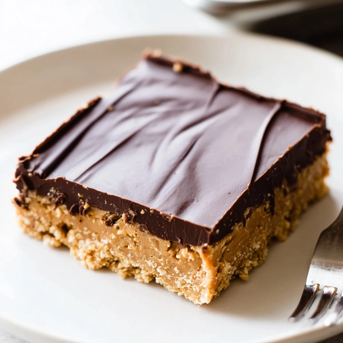 Peanut Butter Bars chilled on parchment, glossy chocolate layer and crunchy crumbs