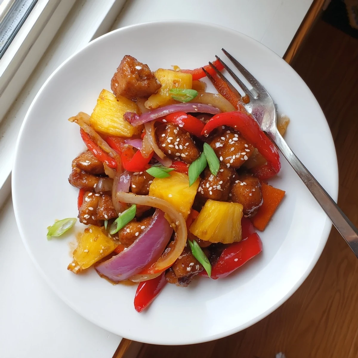 Hawaiian Chicken with caramelized pineapple glaze and colorful bell peppers in a cast iron skillet