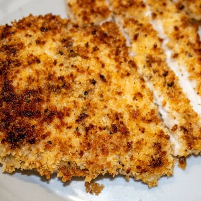 Juicy, tender Air Fryer Parmesan Crusted Chicken with a crunchy golden panko coating on a white plate.